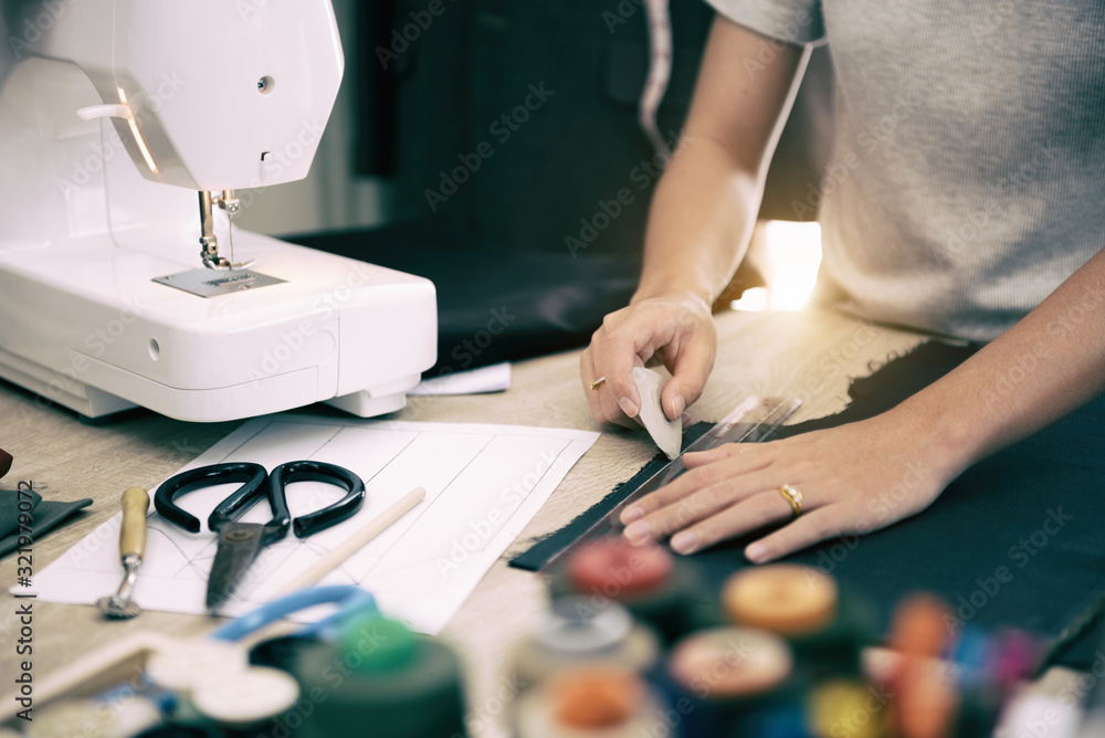 Close up hand of woman while draft patterns on fabric with tailor`s chalk for sewing. Close up hand of woman while draft patterns on fabric with tailor`s chalk for sewing.