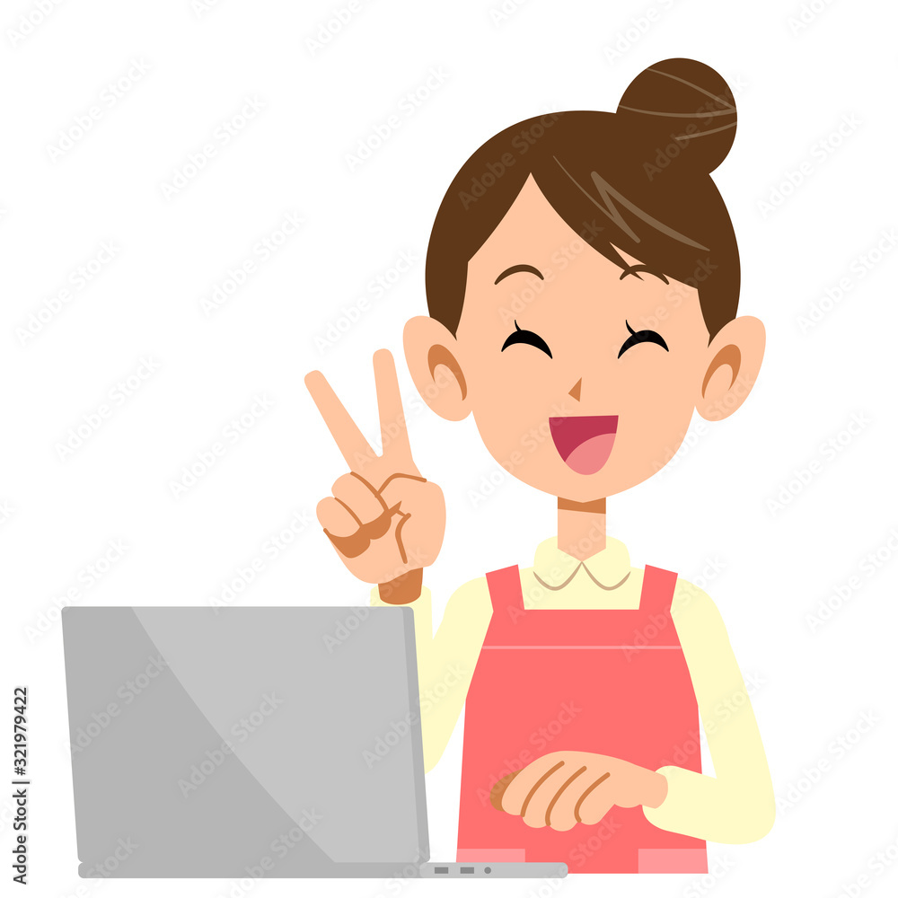 ピースサインを示すノートパソコンを操作するエプロンをつけた女性