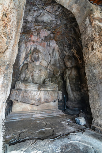 Buddha statue carved in a cave. Figure in Wei style grotto at Longmen Grottoes, Henan province, China