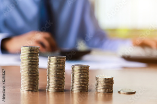 Close up,of people hand putting the coins on the table in his office in finance,investment,saving and banking concept.