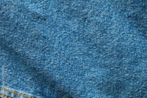 Selective focus blue jean denim top view close up shot to the detail of fabric. textile material and cotton patter tough and durable garment style. For background or wallpaper with copy space for text