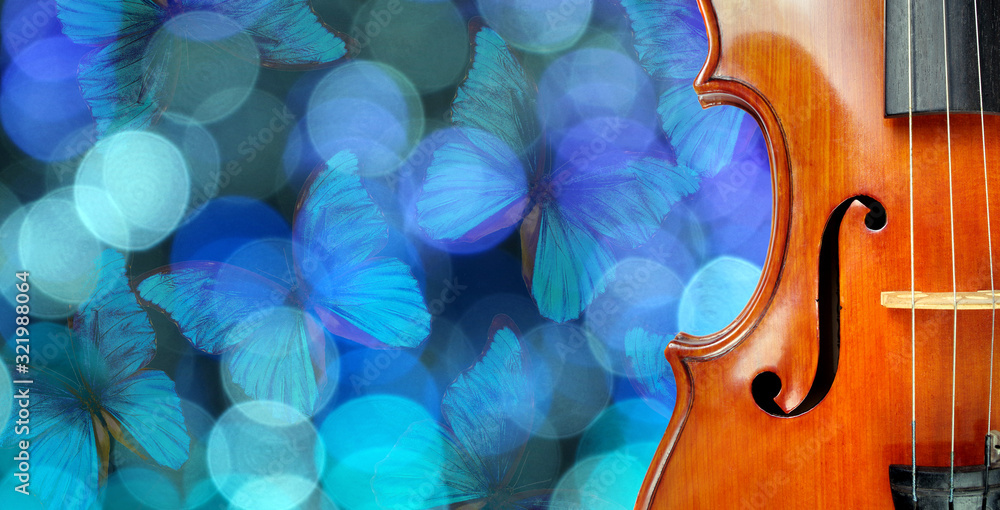 Fototapeta Music concept. Violin on a blurry blue background. Blurry lights and blue morpho butterflies. Blurry garland with blue lights and flying butterflies. Fragment of violin copy spaces.