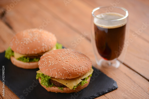 Two hamburgers, cola on the rustic wooden table. Fast food, junk food concept. Food photography concept.