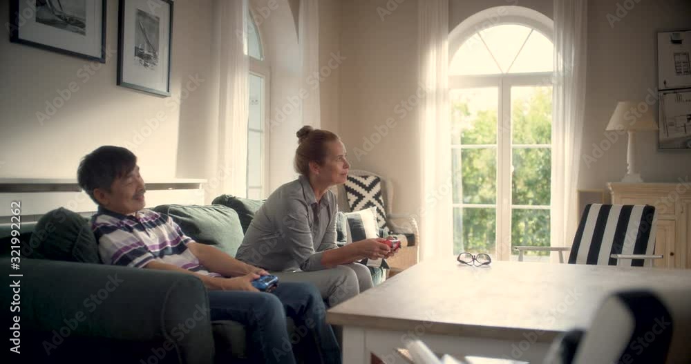 WS Senior Couple Playing a Video Game in Living Room. Shot in R3D (6K RED RAW) WS Senior Couple Playing a Video Game in Living Room. Shot in R3D (6K RED RAW)