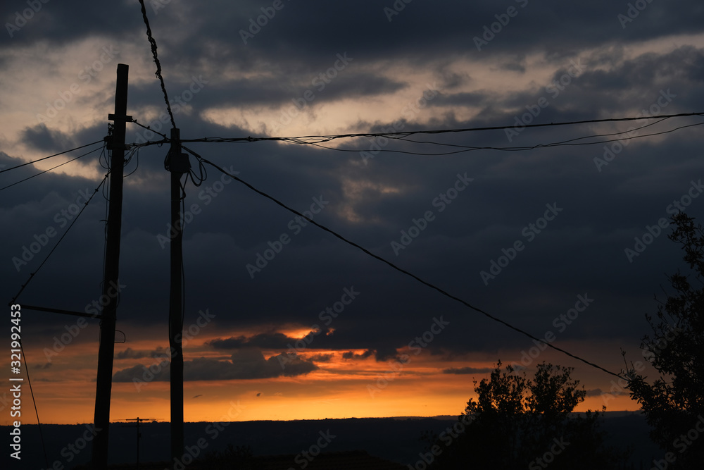 sunset with old electrical pole in roman country side
