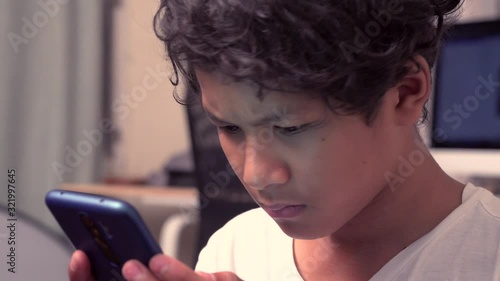 Boy playing on a smartphone in the house