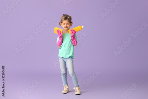 Little housewife with cleaning supplies on color background