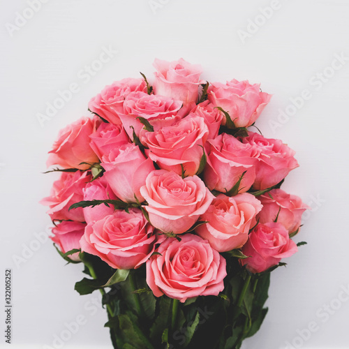 Beautiful bouquet of fresh pink roses in full bloom on white background.