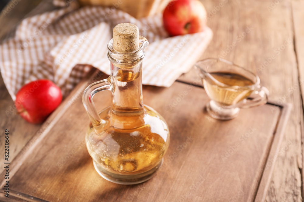 Apple cider vinegar on wooden table Apple cider vinegar on wooden table