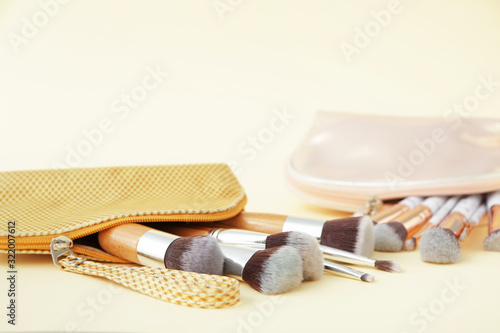 Set of makeup brushes on color background