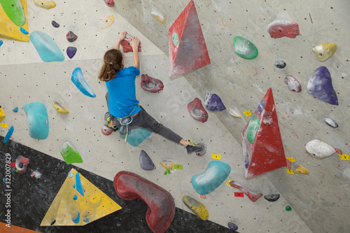 Boy on climbing wall, Bouldersport , boy climbing a rock wall indoor