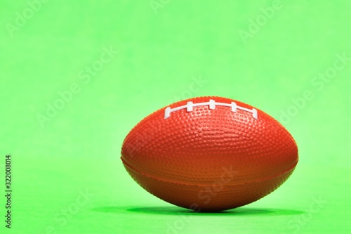 Elongated football sitting at ground level with green background and copy space, Gridiron football season in the USA, ball also represents Aussie Rules and rugby. photo