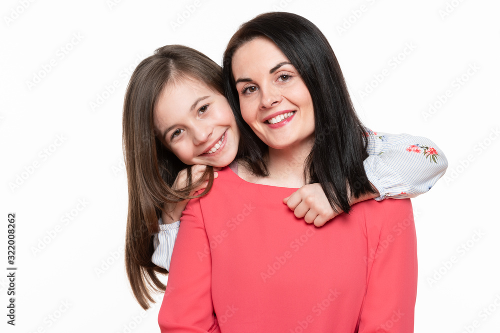 Waist up studio portrait of cute and playful schoolgirl embracing her mother. Happy smiling family background isolated over white. Waist up studio portrait of cute and playful schoolgirl embracing her mother. Happy smiling family background isolated over white.