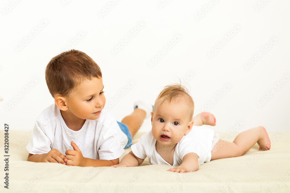 Portrait of brother and sister. Two cute children lying on bed Portrait of brother and sister. Two cute children lying on bed