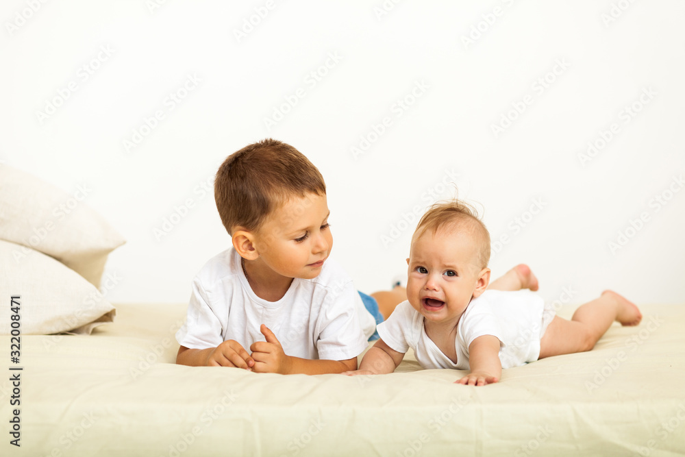 Portrait of brother and sister. Two cute children lying on bed Portrait of brother and sister. Two cute children lying on bed
