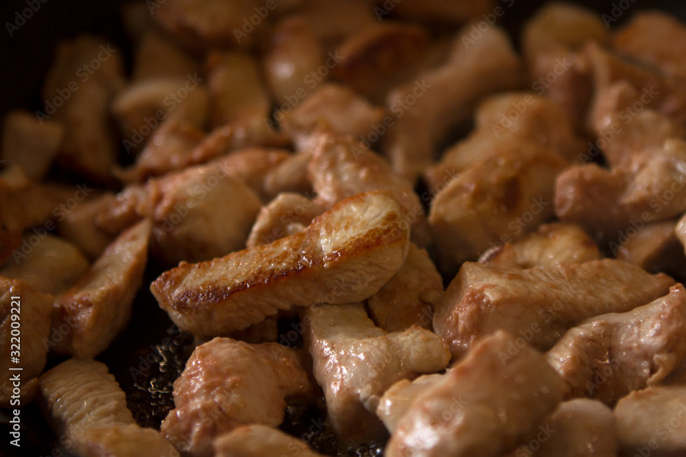 turkey fillet marinated in tomato sauce or chicken fillet fried in a black pan