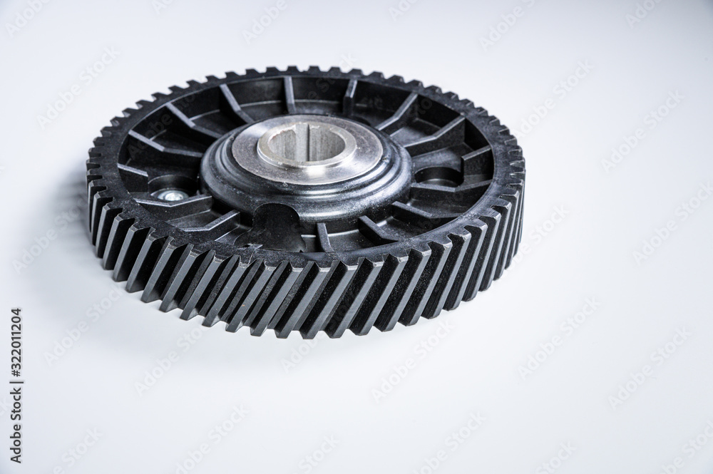 Black polymer gear camshaft with metal base. New spare part for an internal combustion engine on a gray background Black polymer gear camshaft with metal base. New spare part for an internal combustion engine on a gray background