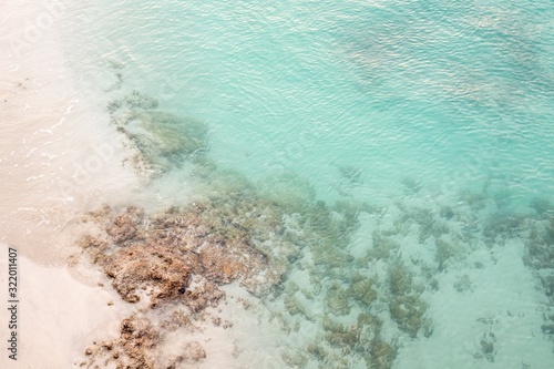 Clear blue sea with corals and a sandy beach