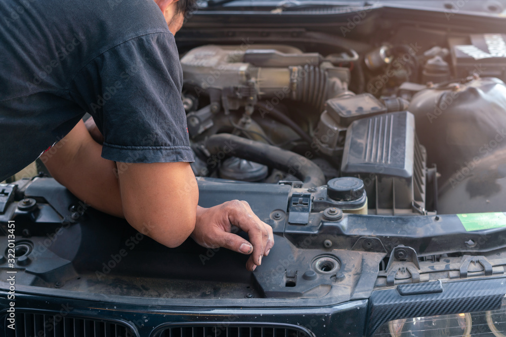 Car mechanic looking and analysis to repairing the engine in the garage Car mechanic looking and analysis to repairing the engine in the garage