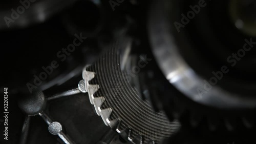 Rotating teeth of three broad cogs riding aslant in a present-day car gearbox    photo