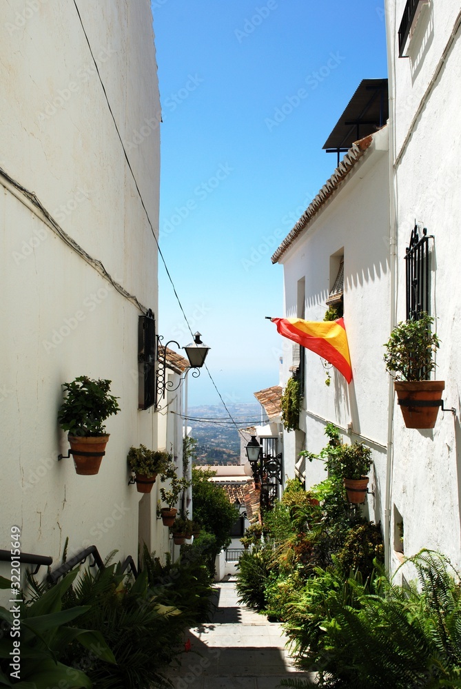 Fototapeta premium View along an old town side street towards the countryside, Mijas, Spain.