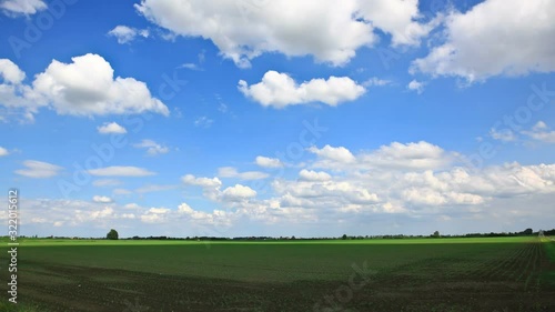 Timelpase of clouds over green field