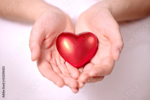 Valentine s day concept. a woman s hand holds a heart on a white background.