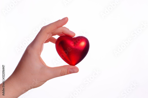 Valentine's day concept. a woman's hand holds a heart on a white background.
