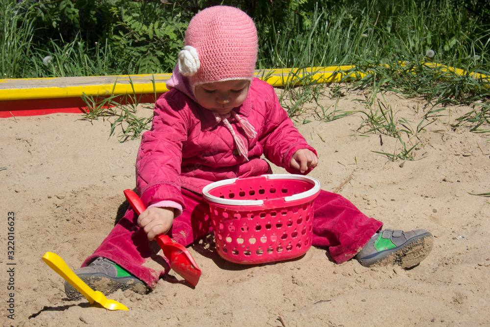 Child of two years old playing with sand and shovel in sandbox on the playground Child of two years old playing with sand and shovel in sandbox on the playground
