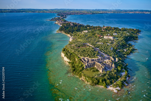 Fototapeta Naklejka Na Ścianę i Meble -  Flight of the Archaeological site of Grotte di Catullo, Sirmione Lake Garda, Italy. Drone video recording