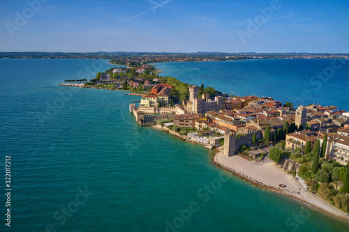 Fototapeta Naklejka Na Ścianę i Meble -  Unique view. Aerial photography, the city of Sirmione on Lake Garda north of Italy. In the background is the Alps. Resort place. Aerial view. Sirmione Castle,