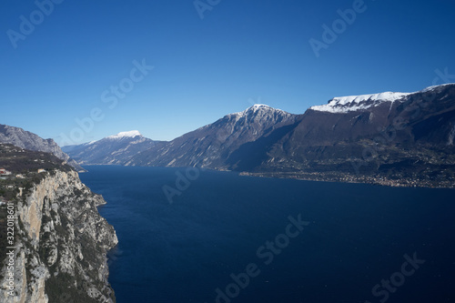 Rocks on Lake Garda, Italy aerial view. Mountain tops in the snow