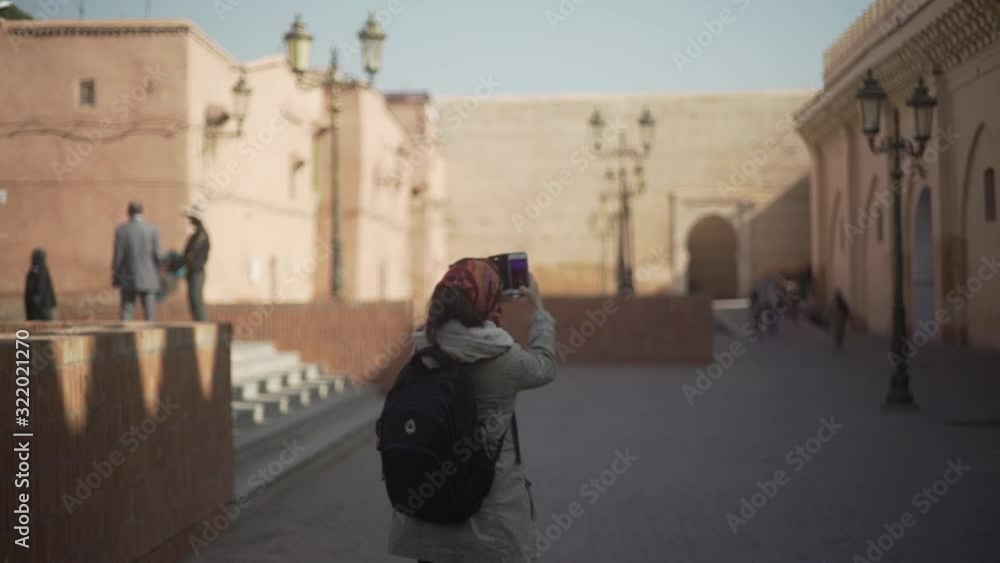 day shot of young female tourist taking photo with phone at Marrakesh Morocco city , sightseeing explore the city holiday day shot of young female tourist taking photo with phone at Marrakesh Morocco city , sightseeing explore the city holiday