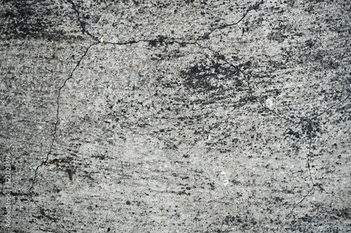 Texture of an old cracked concrete wall. Background image of a worn gray concrete surface