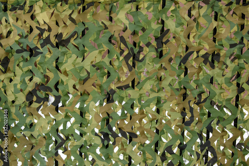Summer camouflage net for backdrop. On a brown and white background. Colors are green and black.
