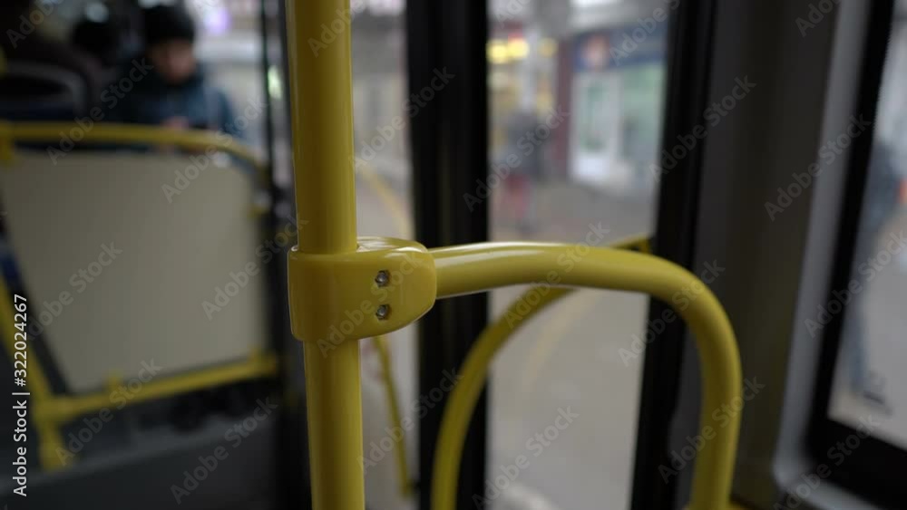 View from the interior of a bus traveling through the city. A close-up of the yellow handrail, followed by a blurry view of the bus interior and glass doors. Abstraction. 4K. View from the interior of a bus traveling through the city. A close-up of the yellow handrail, followed by a blurry view of the bus interior and glass doors. Abstraction. 4K.