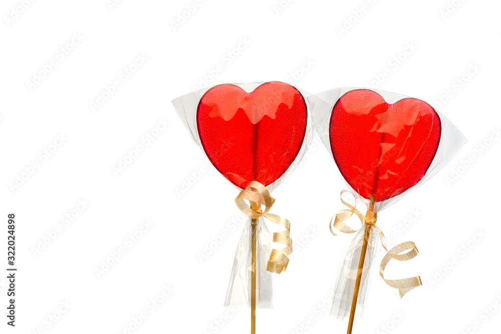 Lollipop. Two  red heart-shaped  lollipops  in transparent packaging on a white isolated background for Valentine's Day. Isolate.