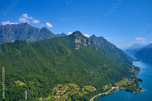Fototapeta Naklejka Na Ścianę i Meble -  Panoramic view of the mountains and Lake Idro.  Reflection in the water of the mountains, trees, blue sky. Aerial view, drone photo