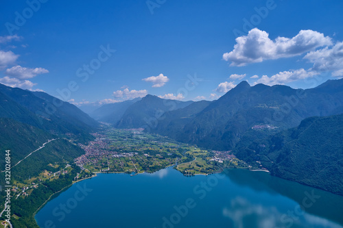 Panoramic view of the mountains and Lake Idro.  Reflection in the water of the mountains  trees  blue sky. Aerial view  drone photo