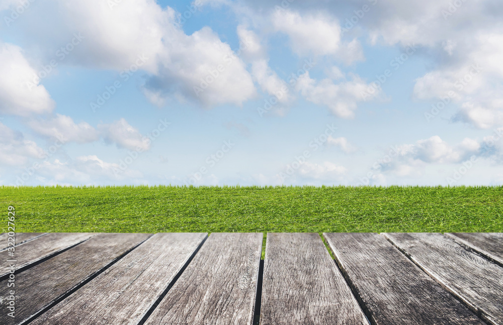 Green grass, blue sky and white clouds with wooden floor backgrounds Green grass, blue sky and white clouds with wooden floor backgrounds