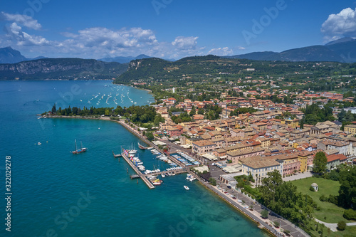 Fototapeta Naklejka Na Ścianę i Meble -  Aerial photography. Beautiful coastline. In the city of Bardolino, Lake Garda is the north of Italy. View by Drone. Docked yachts parking in Port.