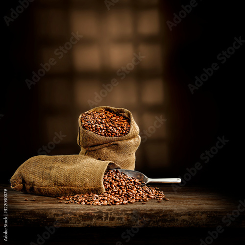 Fresh coffee grains in sack and dark interior with sadows.Copy space for your decoration. 