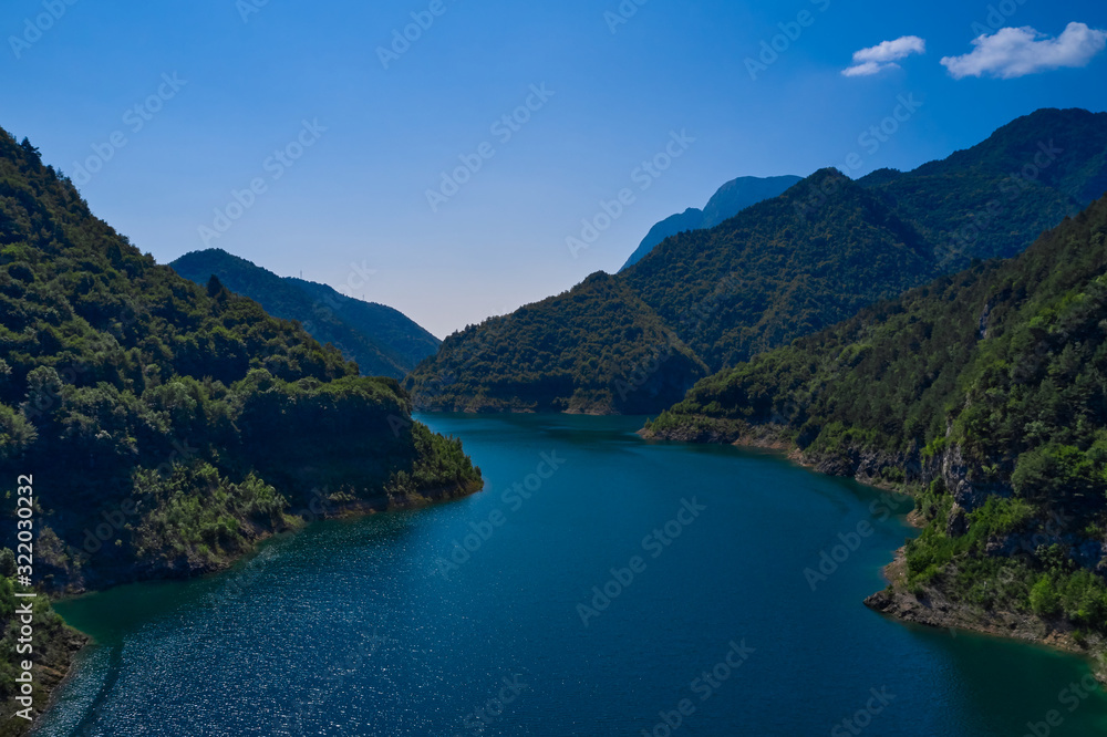 Aerial view, Lake Valvestino, Italy. Beautiful lake between the mountains. Cumulus clouds, blue sky