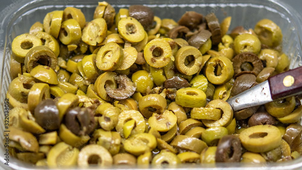Olive slices stored in a plastic box in close up Olive slices stored in a plastic box in close up