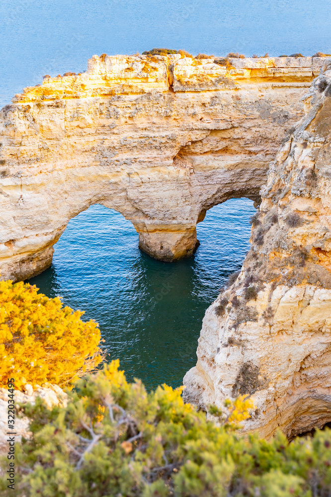 Beautiful view of Praia da Marinha. Rocks, cliff  and green plants in Algarve, Faro, Portugal. turquoise water of Atlantic ocean. Heart shape in rocks. Love to adventure. Copy space.