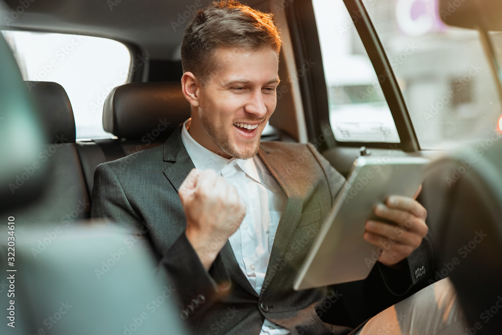 Φωτογραφία young happy successful businessman checking stock market , looks winning, invest