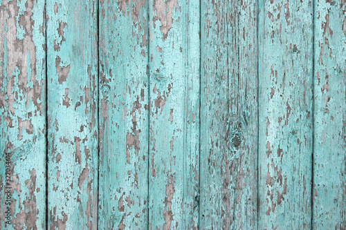 Crackled paint on old light blue wood planks.