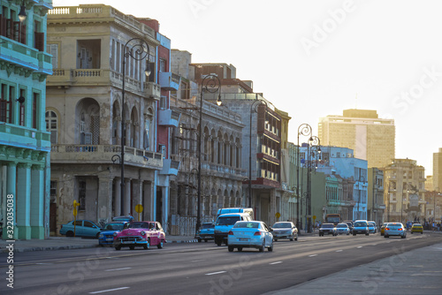 Malecon promenade with retro cars at sunset in Havana, Cuba