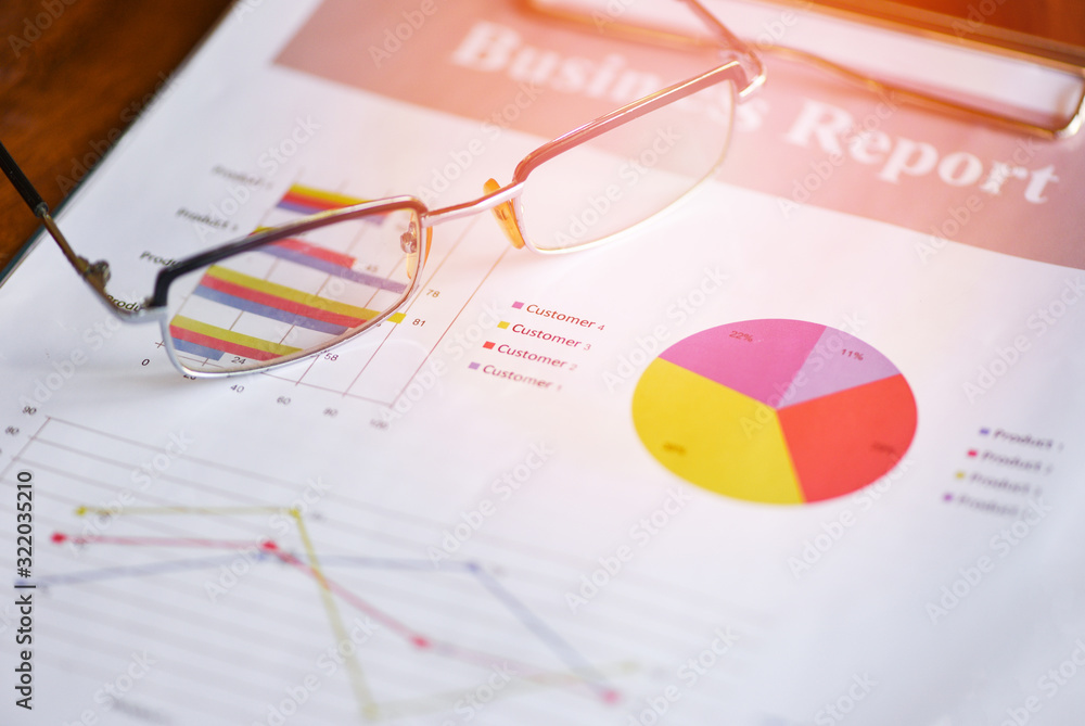 Glasses on diagram graphs business chart paper document working in the office - Business report plan concept Glasses on diagram graphs business chart paper document working in the office - Business report plan concept