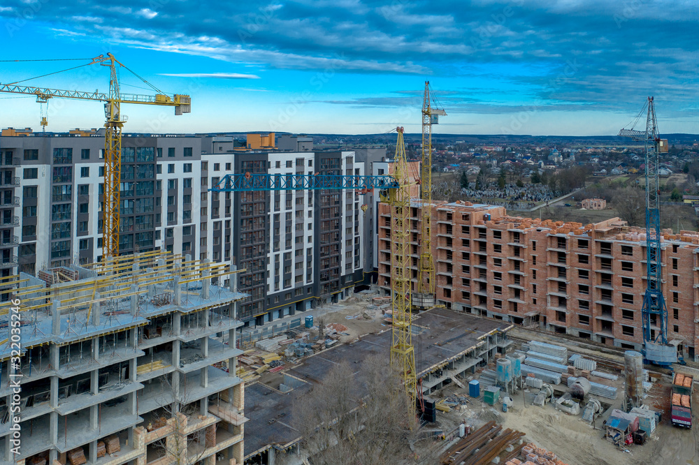 Fototapeta premium Construction site background. Hoisting cranes and new multi-storey buildings. I.ndustrial background